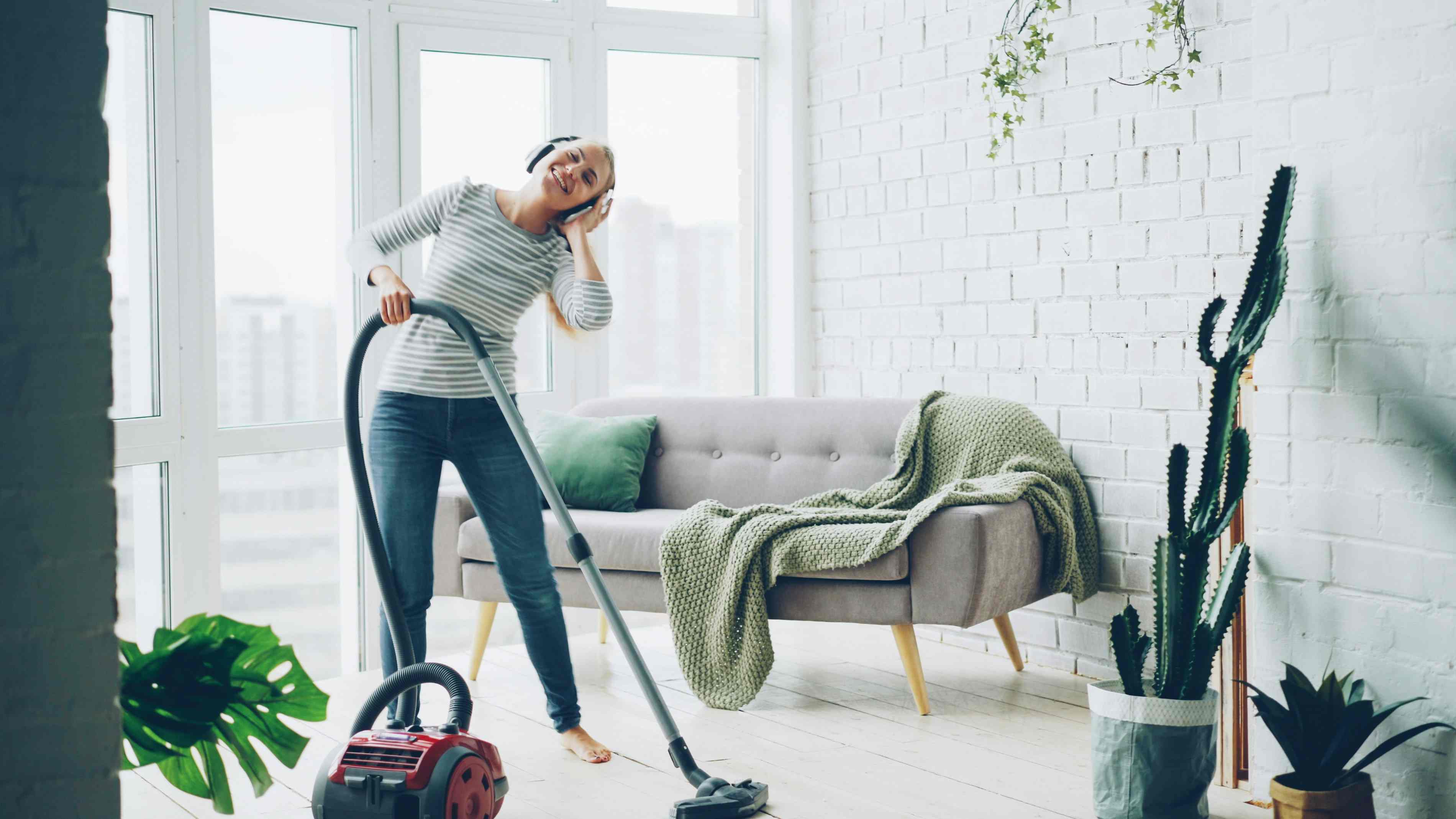 Professional cleaner vacuuming a bright living room